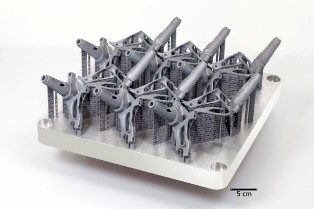 Several structural components arranged on a base plate after a selective laser melting process.