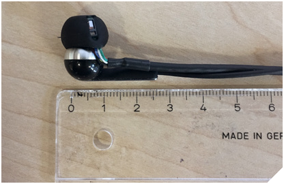 Figure 1. Test system with an integrated optical sensor and accelerometer with scale shown for comparison.